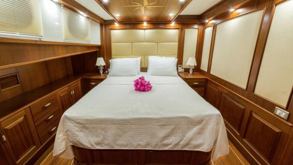 Spacious cabin with double bed and elegant wooden decor on the Halcon Del Mar.